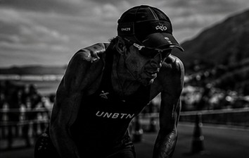 Triathlete hunched over the handlebars late in a race.